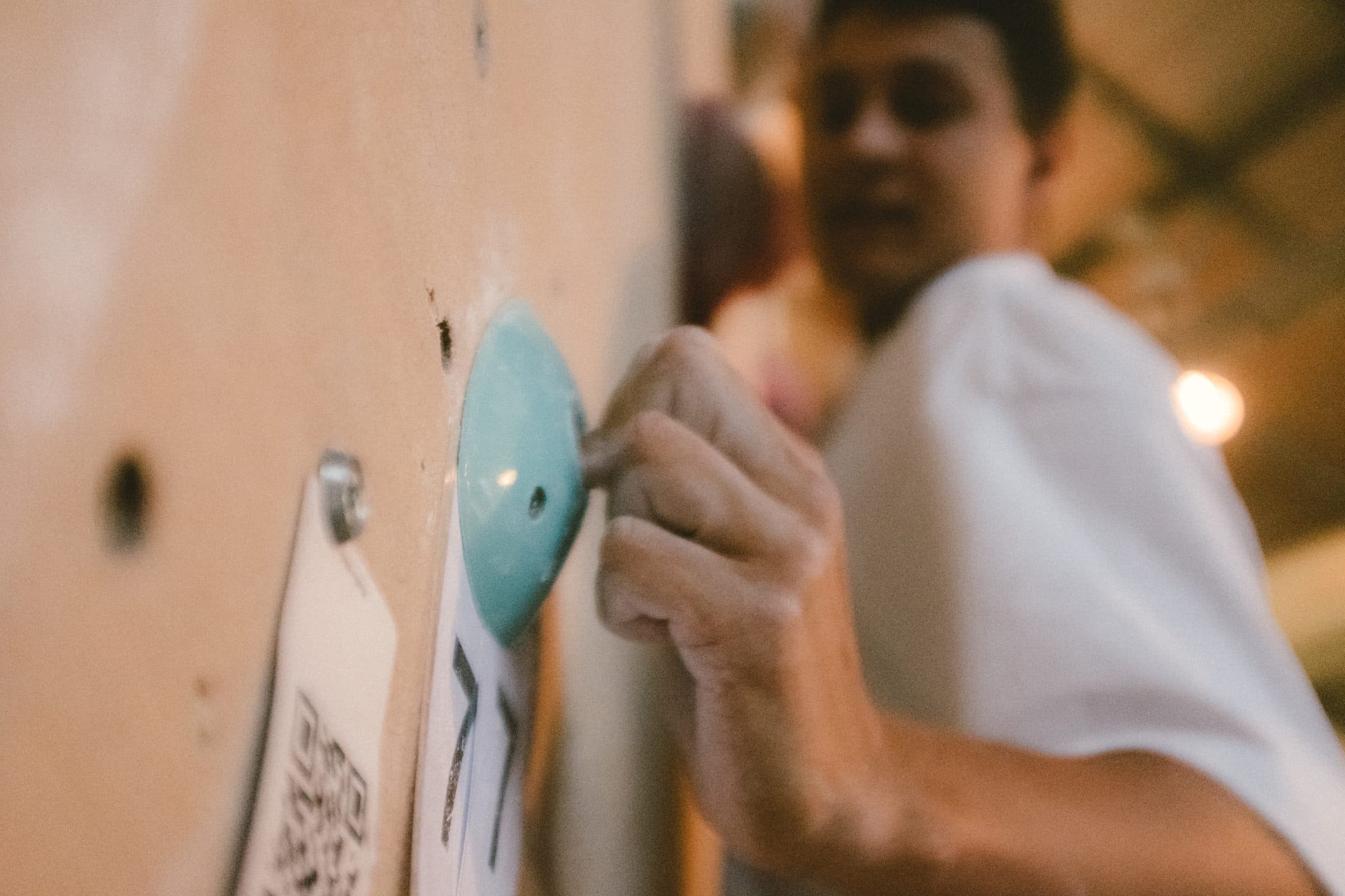 Hand an einem Griff neben dem Routenschild mit QR-Code
